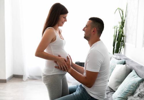 mãe gestante e pai fazendo carinho na barriga do bebê