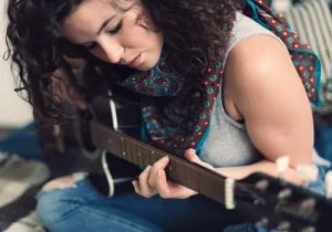 mulher tocando no violão sua música favorita